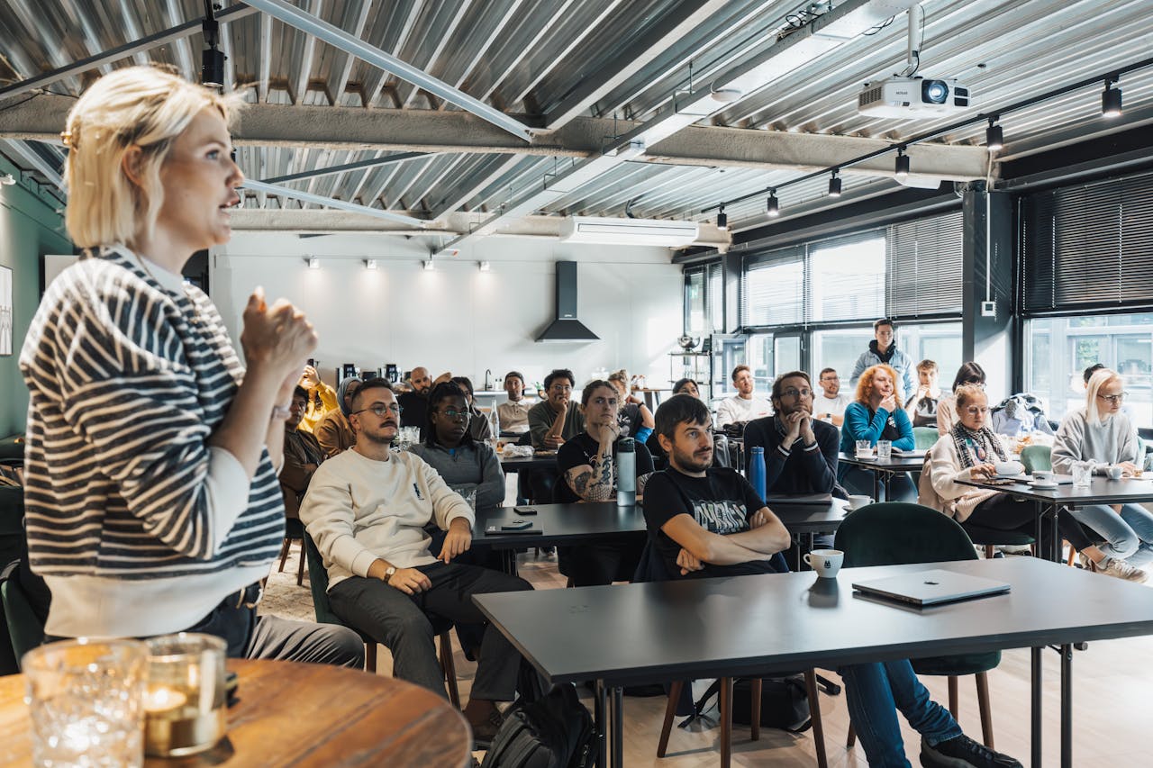 services-02 A dynamic speaker engaging a diverse audience in a modern workshop setting.